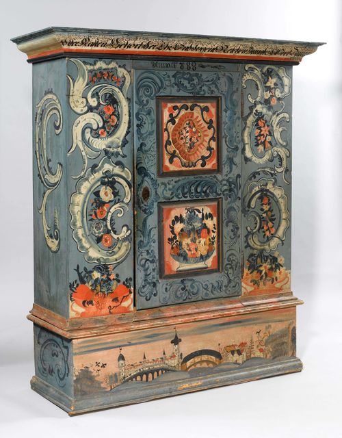 PAINTED ARMOIRE,Toggenburg, dated 1788 and inscribed DISER KASTEN GEHÖRT DER EHR UND TUGENDREICHEN JUNGFER ELSBET ZIMERMÄNIN. Pine, richly painted with rocailles, flowers, fruit bowls, and a city view on a blue, partly red-marbled ground, and slightly carved. Metal escutcheon. 156x57x179 cm. 1 key. Minor losses, the sides of the crown not original.