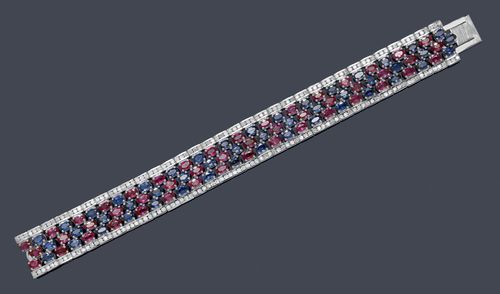 RUBY, SAPPHIRE AND DIAMOND BRACELET. White gold 750. Decorative, elegant bracelet of three lines of alternately set lines of oval rubies and sapphires weighing ca. 29.60 ct. The border is additionally decorated with numerous brilliant-cut diamonds weighing ca. 4.90 ct. L ca. 18 cm.