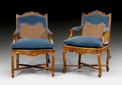 PAIR OF FAUTEUILS "A LA REINE", Regence, Paris ca. 1730. Walnut, finely carved with shells, leaves and decorative frieze. Caning. Dark blue velour cushion. 64x51x50x97 cm. Provenance: - from a Swiss private collection.