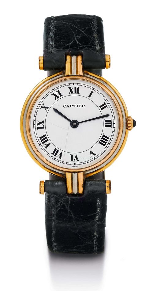 LADY'S WRISTWATCH, CARTIER, 1990s. Yellow gold 750. Round, flat case with ribbed, tricolour lunette and attaches. Cream-coloured dial with black Roman numerals and hands, hairline cracks. Quartz movement. Black original leather band with gold-plated Cartier clasp. With Cartier case and certificate, December 1992.