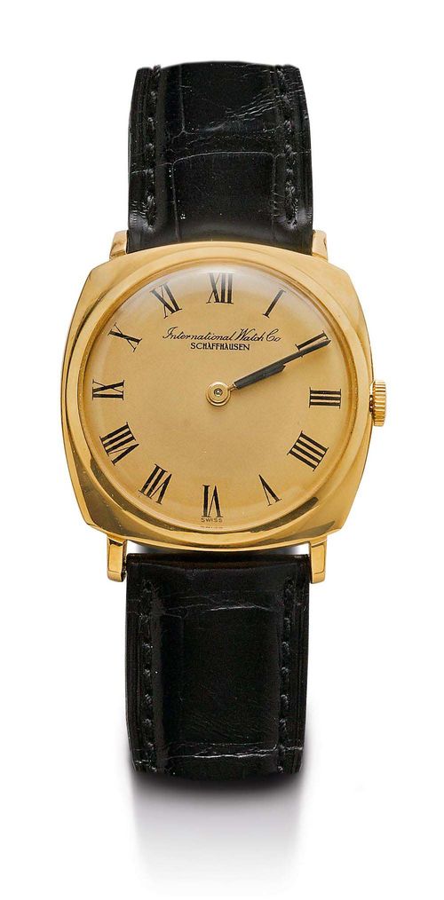 WRISTWATCH, IWC, 1960s. Yellow gold 750. Ref. 1218. Tonneau-shaped case No. 1767697. Gold-coloured dial with black Roman numerals and black painted hands. Hand winding movement No. 1702625, Cal. 421 with Breguet spring and swan neck regulator. Black leather band with gold-coloured IWC clasp. D 35 x 31 mm.