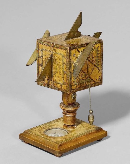 A WOOD AND PAPER CUBE SUNDIAL, Germany, 2nd half of 18th c. Rectangular base with compass. The cube with the dials mounted on turned shaft and with brass gnomon. Verso sign. D.BERINGER. H ca. 19 cm.