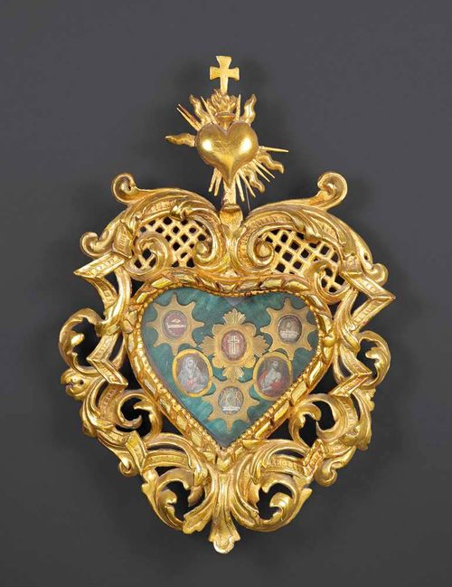 MONASTERY WORK WITH RELICS,Baroque, probably Switzerland circa 1730. Heart-shaped carved and gilt wooden frame with 6 engraved brass medallions, 3 of which with relics and 2 with finely painted pictures of Mary and Jesus. H 43 cm. Provenance: - Kloster Frauenthal, Hagendorn. - Swiss private collection.