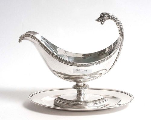 SAUCE BOAT. No mark. Probably France, 19th century.Smooth sided, with continuous palm frieze. The handle in the form of a fabulous creature. L 20 cm. 620 g.