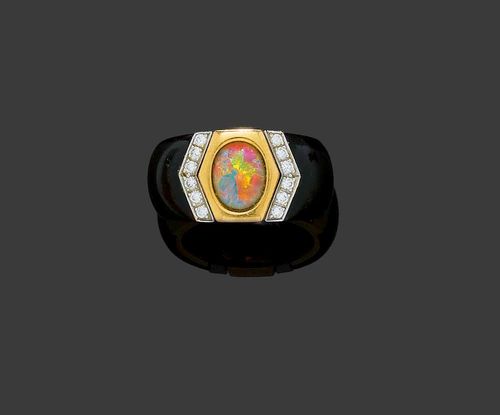 OPAL, DIAMOND AND WOOD RING, PÉCLARD. Yellow and white gold 750. Fancy band ring set with 1 opal of 0.98 ct, red, yellow, blue and green in colour, flanked by 12 brilliant-cut diamonds totalling 0.18 ct and 2 cut palm wood parts. Size ca. 49. With copy of invoice.