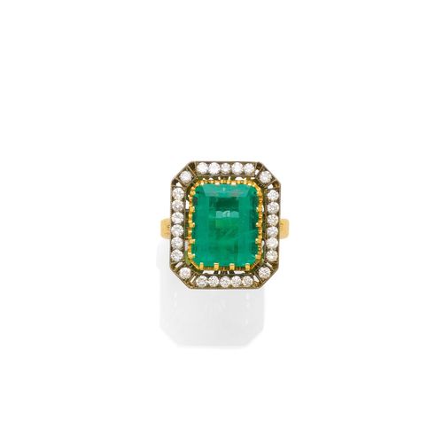 EMERALD AND DIAMOND RING. Yellow gold 750. Set with 1 step-cut emerald weighing ca. 5.60 ct, within a border of 26 brilliant-cut diamonds weighing ca. 0.70 ct. Size ca. 55.
