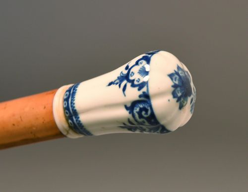 WALKING STICK,France, St. Cloud, 18th century. Small, white porcelain grip with blue underglaze painting. Malacca wood stick with horn tip. L 86.5 cm.