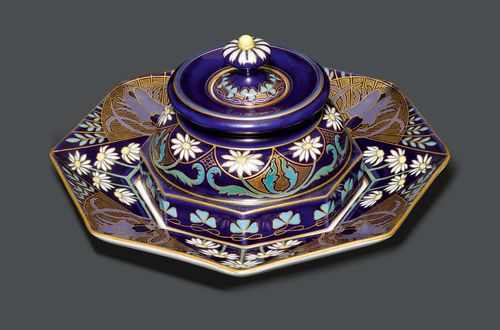 MEISSEN INKWELL, circa 1910 Colourful, painted porcelain. Octagonal shape decorated with marguerites and stag beetles. The bottom is inscribed with a sword mark. D 21 cm.