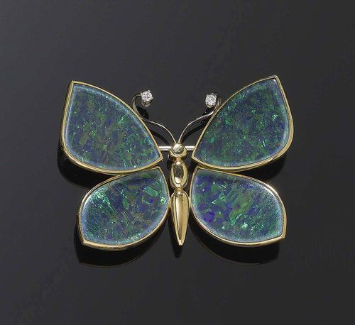 OPAL AND GOLD BROOCH/PENDANT. Yellow gold 750. Decorative butterfly brooch, the wings are each made of one cut, blue/green opal doublette, the feelers are decorated with 2 brilliant-cut diamonds totalling ca. 0.05 ct. Hinged eyelet.