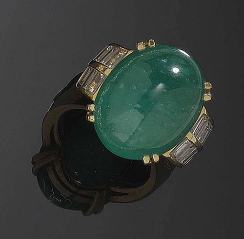 EMERALD AND DIAMOND RING. Yellow gold 750. Casual-elegant ring, the top is set with 1 emerald cabochon of ca. 20.00 ct, flanked by 20 baguette-cut diamonds totalling ca. 1.00 ct. Size ca. 49.