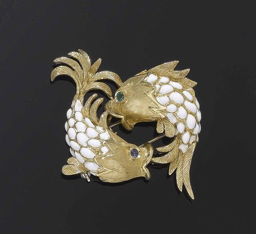 GOLD AND ENAMEL BROOCH. Yellow gold 750. Highly decorative brooch of two plastically designed fish with scales of white enamel, satin-finished heads and engraved fins as well as 1 sapphire and 1 emerald as eyes.