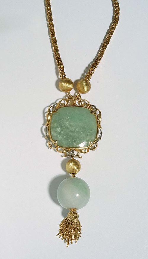 GOLD AND JADE SAUTOIR, E. MEISTER. Yellow and white gold 750. Casual-elegant chain with a pendant consisting of a light-green jade disc of ca. 33 x 37 mm, framed with bicolour band motifs, underneath, on a movable mount, is a satin-finished gold bead above a light-green jade bead of ca. 27 mm Ø with a gold tassel at the end. L ca. 79.5 cm.