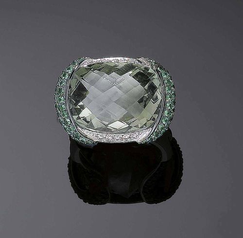 PRASIOLITE AND TSAVORITE DIAMOND RING. White gold 750. Modern ring, the oval top is set with 1 prasiolite, the setting and the ring shoulders are set with numerous tsavorites and brilliant-cut diamonds. Gemstones totalling ca. 25.00 ct, brilliant-cut diamonds ca. 0.20 ct. Size 55. Matches the following lot.