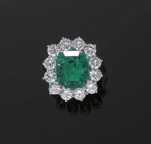 EMERALD AND BRILLIANT-CUT DIAMOND RING. White gold 750. Very elegant, attractive ring, the top set with 1 octagonal Columbian emerald of  7.03 ct., in a surround of 12 brilliant-cut diamonds totalling ca. 2.90 ct and of fine quality. Size 54. With SSEF Report No. 47297, moderately enhanced by oil, September 2006.