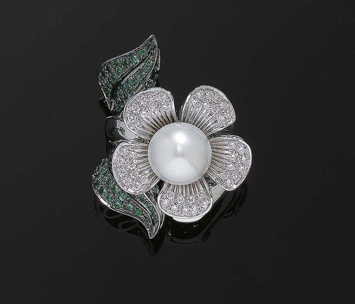 PEARL AND DIAMOND TSAVORITE RING. White gold 750. Highly decorative, unusual ring, the top in the shape of a flower with leaves. At the centre of the flower: a freshwater cultured pearl of ca. 11.4 mm Ø surrounded by 45 brilliant-cut diamonds totalling ca. 0.70 ct, the two rhodanized black leaves are decorated with 60 tsavorites. Size 57.