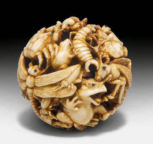 A GLOBULAR OPENWORK IVORY OKIMONO OF DIFFERENT KINDS OF LITTLE ANIMALS.