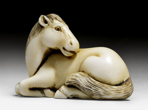 A MARINE IVORY NETSUKE OF A RECUMBENT HORSE.