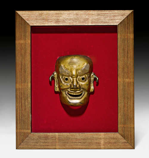 AN UNUSUAL GILT BRONZE MASK.