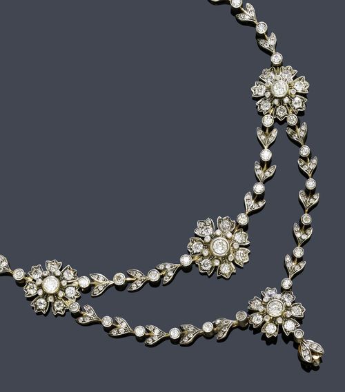DIAMOND NECKLACE, KÖCHERT, Vienna, ca. 1890. Silver over pink gold. Fancy  garland necklace with double-row front of 9 graduated flower motifs, each  set with 15 old European-cut diamonds flanked by numerous diamond-set