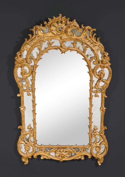 MIRROR "AUX CARTOUCHES", Louis XV, Paris circa 1760. Pierced and richly carved giltwood. H 170 cm. W 106 cm.