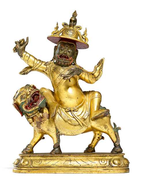 A GILT BRONZE FIGURE OF DORJE LEGPA ON HIS LION.