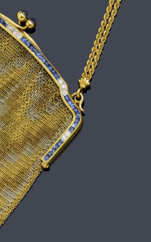 SAPPHIRE AND DIAMOND CLUTCH BAG, ca. 1920. Yellow gold and platinum. Decorative, two-colour, knit clutch bag, the bow set throughout with 46 square-cut sapphires, weighing ca. 6.00 ct, and 13 old European cut diamonds, weighing ca. 0.70 ct, the clasp decorated with 2 sapphire cabochons. As a handle, a double cord chain, the centre with 2 circle motifs set with 4 small sapphire cabochons. Engraved No. 5135 12. With case.