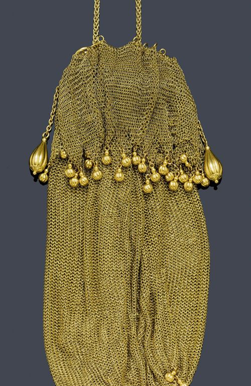 GOLD CLUTCH BAG, France, ca. 1920. Yellow gold 750, 322g. Very decorative, knit clutch bag with a band of gold rings and a knitted cord as a drawstring, the ends each decorated with numerous ribbed gold spheres.