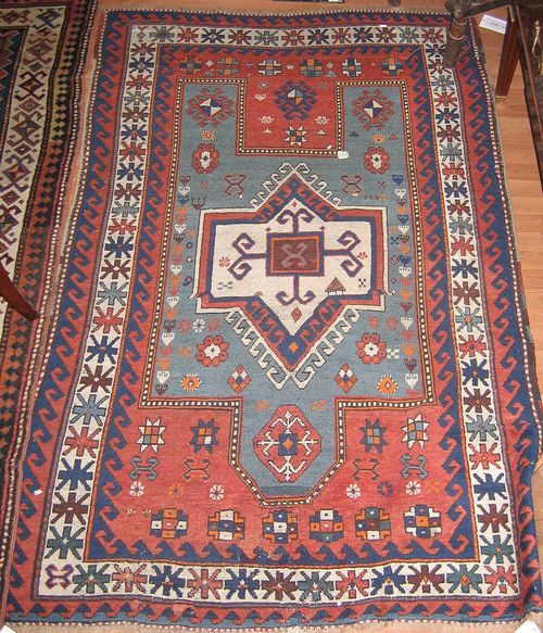 FACHRALO antique.Red central field with a white and green central medallion, geometrically patterned, white edging, strong signs of wear, 200x125 cm.