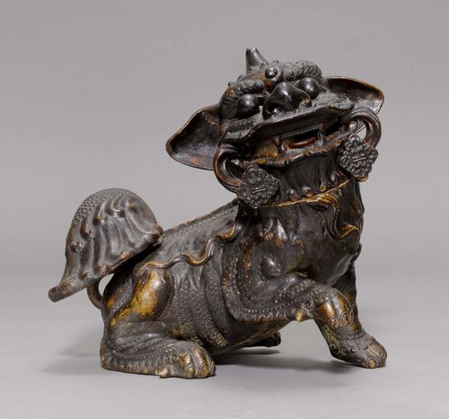 CERAMIC FO DOG.China, 19th c. H 35 cm. Crouching Fo dog with raised right front paw. The glaze imitates the dark patina of bronze. Head and tail detachable.