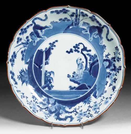 BLUE AND WHITE PLATE.Japan, Edo period, D 30.5 cm. With figural landscape of rocks and waterfall and tiger on the side. Minor chips on edge. Proceeds to the Basel Zoo.