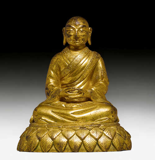 A GILT BRONZE FIGURE OF A MONK.