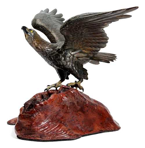 A LARGE BRONZE EAGLE ON A ROCK.