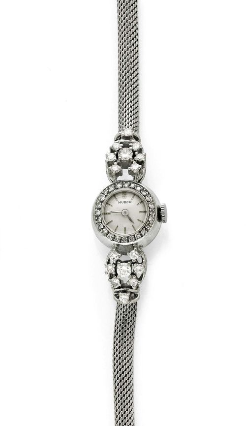 DIAMOND AND GOLD LADY'S WRISTWATCH, HUBER, ca. 1950. White gold 585, 18g. Small, round case No. 8675 with diamond lunette. Silver-coloured dial with gold-coloured indices and silver-coloured hands, signed Huber. Hand winder, movement Cal. 6P, signed Piaget. Diamond-set attaches weighing ca. 0.30 ct and bracelet with knitted pattern, L ca. 18 cm. With original case.