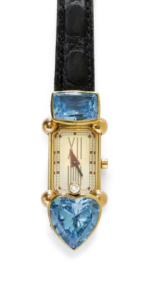 DIAMOND GOLD LADY'S WRISTWATCH, MISANI. Yellow gold 750. Hermitage model. Rectangular gold case. Attaches asymmetrically set with 1 brilliant-cut diamond weighing ca. 0.15 ct, 1 blue, heart-shaped and 1 antique-oval cubic zirconia. Cream-coloured dial with dot indices and red, triangular hour hand. Quartz movement. Black leather band with gold-coloured fold-over clasp. With case.
