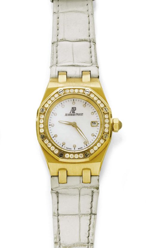 DIAMOND LADY'S WRISTWATCH, AUDEMARS PIGUET, ROYAL OAK, 1990s. Yellow gold 750. Ref. F65825. Tonneau-shaped case No. F 65825.0451 with octagonal brilliant-cut diamond lunette and screw-down back. Mother-of-pearl dial with diamond indices, luminous hands, date at 3h, signed. Quartz movement, Cal. 2712. White leather band with fold-over clasp. D 42 x 33 mm. With case, instructions and warranty, July 1996.