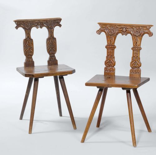 LOT OF 2 SIMILAR STABELLE CHAIRS, In the Renaissance style, Switzerland, 19th/20th century. Walnut and hardwood, carved with leaves, volutes, masks, and the coat-of-arms of the Sprüngli family.
